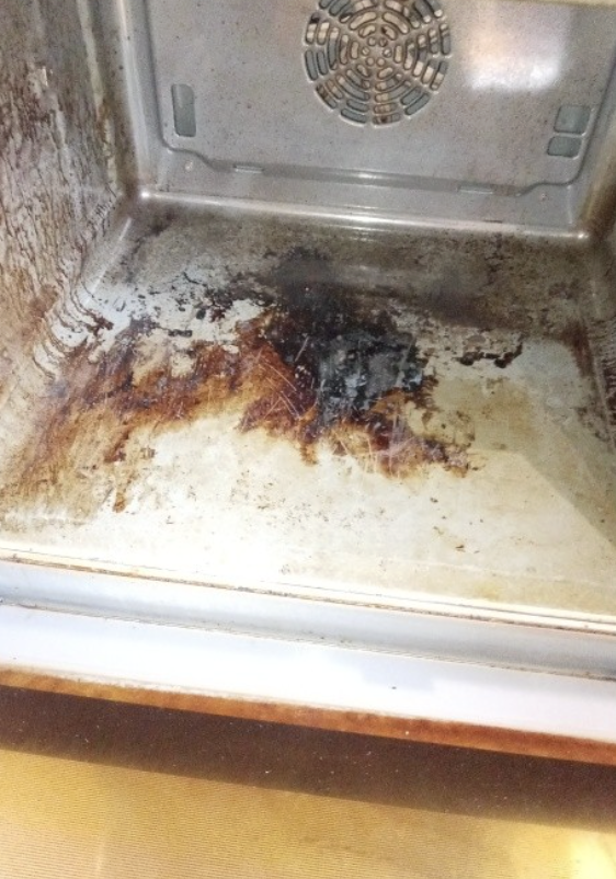 Oven interior before cleaning — burnt residue on base
