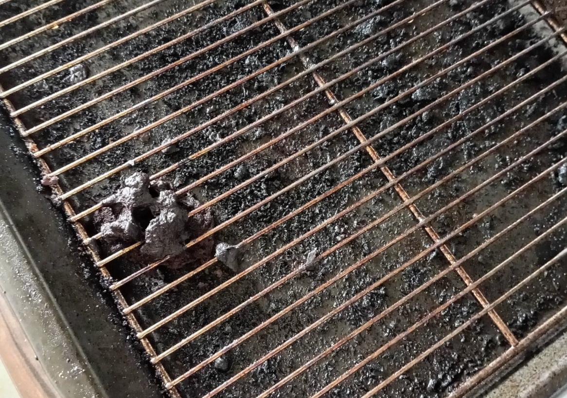 Oven rack before cleaning — heavily carbonised